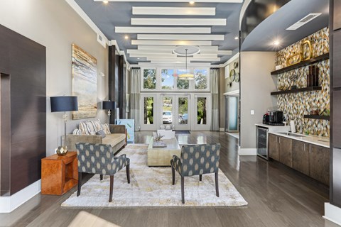 A modern living room with a grey sofa and a patterned armchair.