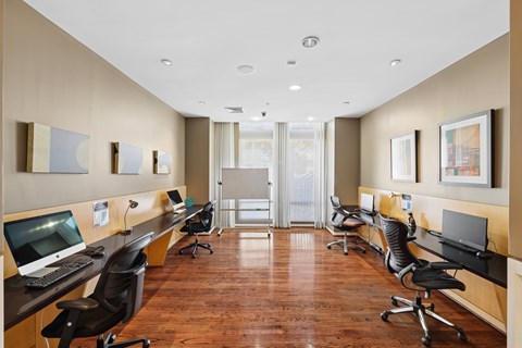 A long, narrow office space with wood floors and beige walls.