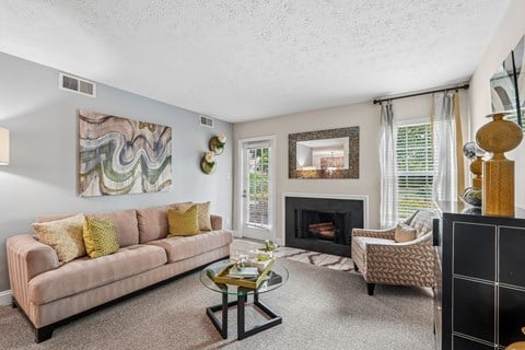 A living room with a fireplace and a painting on the wall.