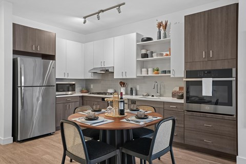 A modern kitchen with a table set for two.