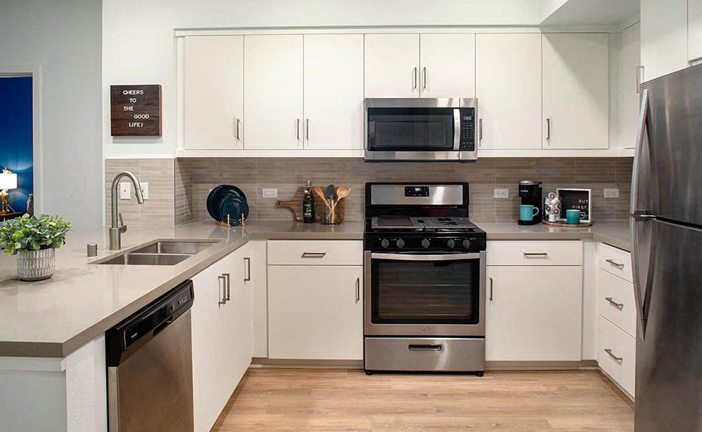 a kitchen with stainless steel appliances and white cabinets