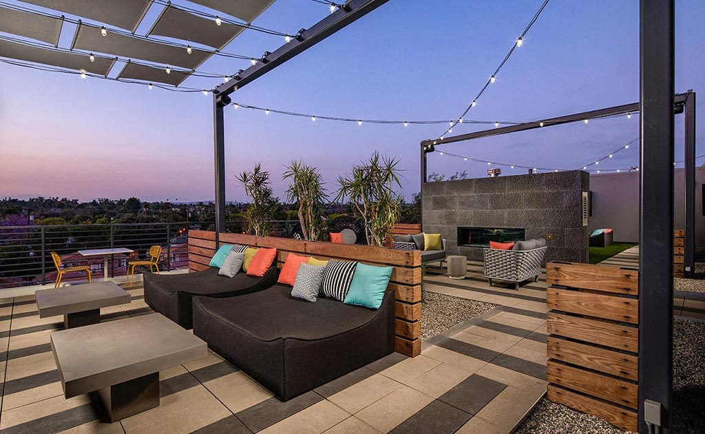 a rooftop patio with couches and a fire pit
