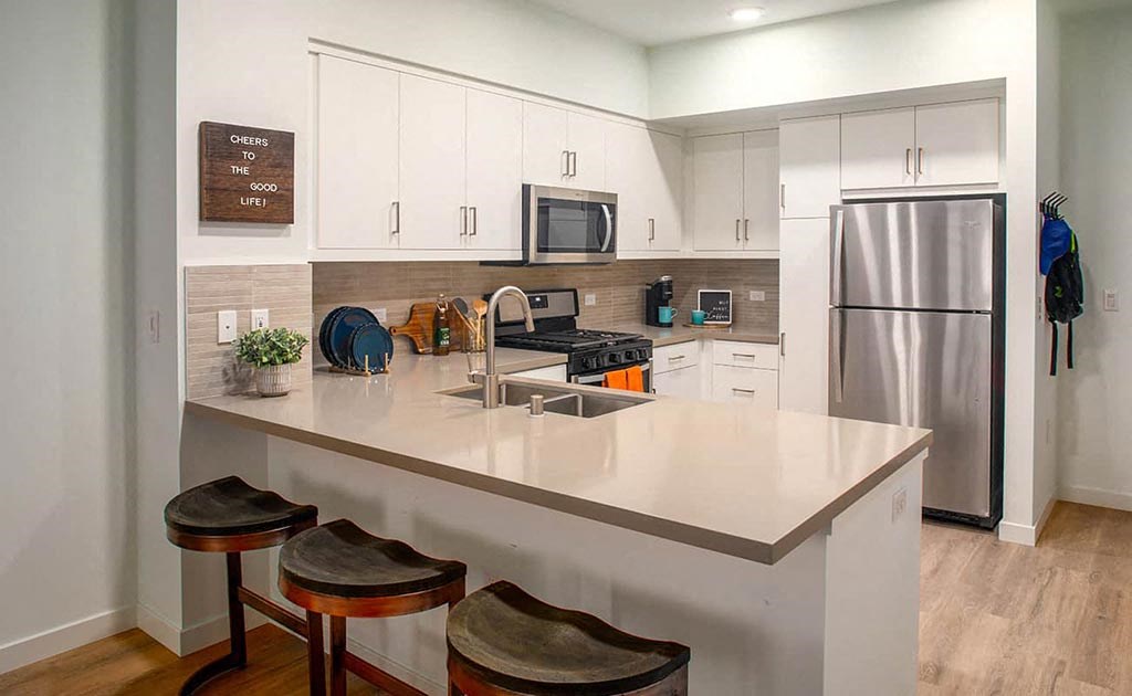 a kitchen with a counter top and a stainless steel refrigerator