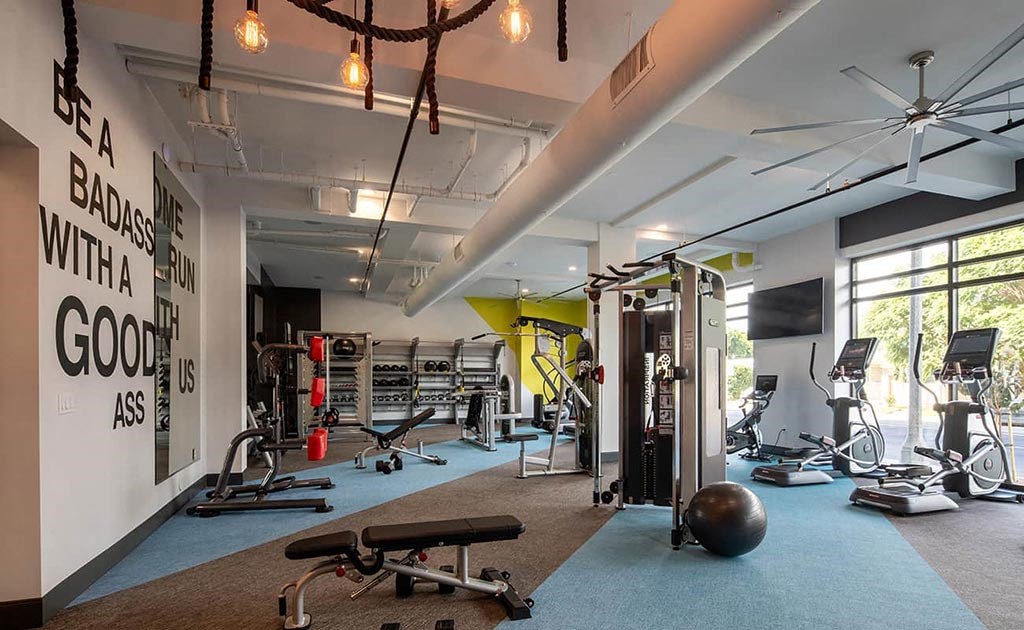 a workout room with weights and other exercise equipment and a window