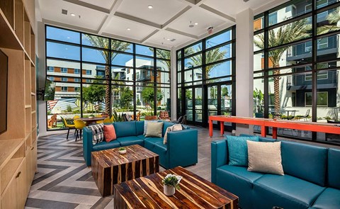 a lobby with blue couches and tables and large windows