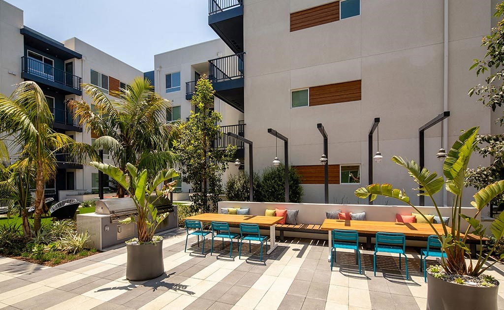 a patio with tables and chairs in a courtyard