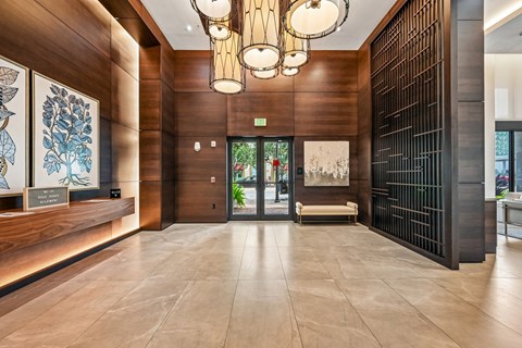 A hallway with a wooden floor and a black gate on the right side.