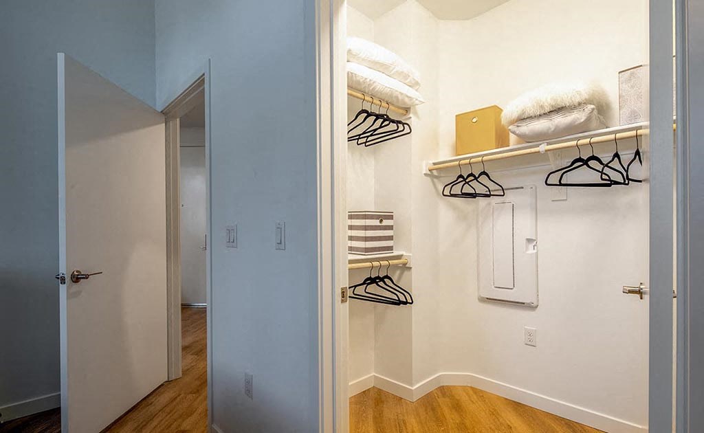 a bathroom with a closet and a mirror and a door