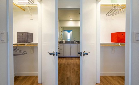 a view of a closet and a kitchen from behind doors