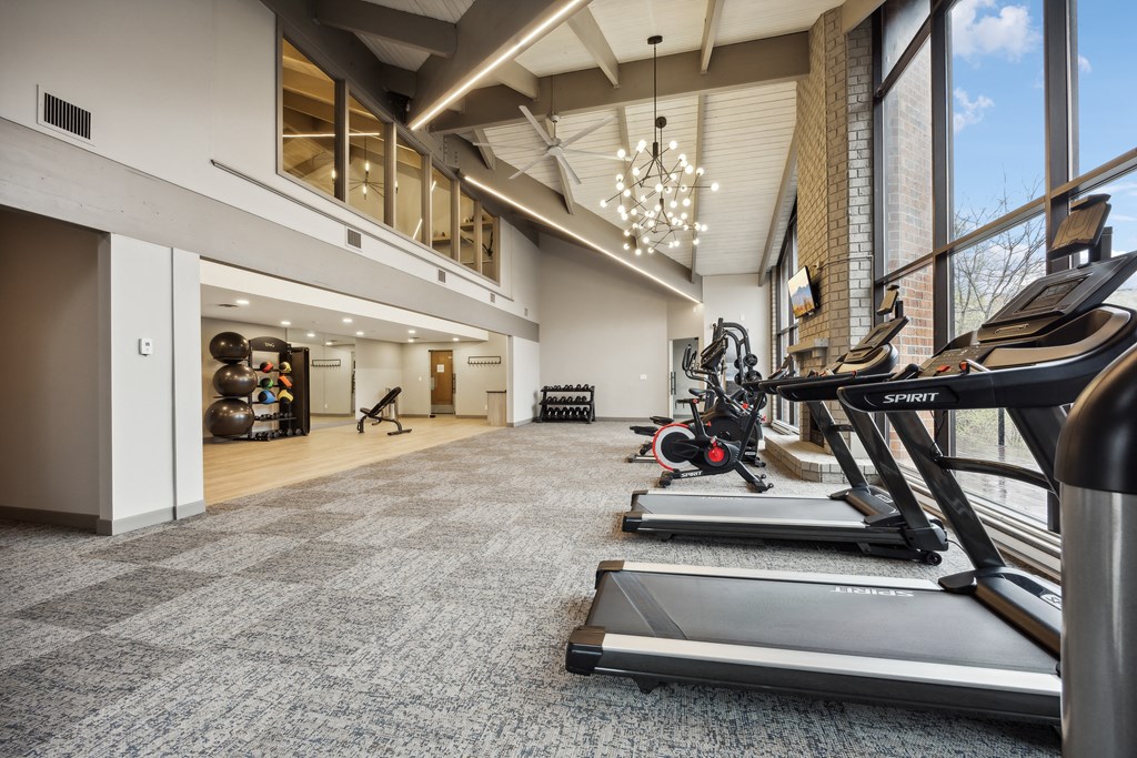 a gym with treadmills and other exercise equipment in the lobby of a building