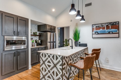 an open kitchen with a large island with a counter top and two chairs