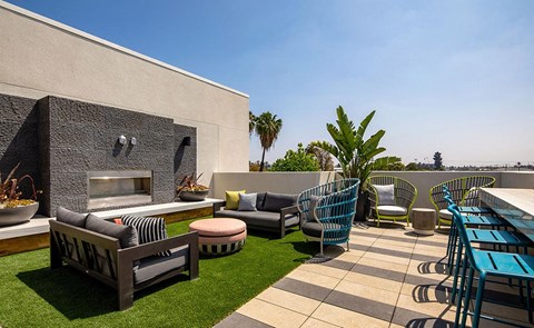 a rooftop patio with furniture and a fireplace