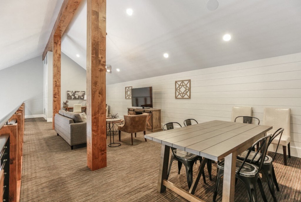 a dining area with a table and chairs and a living room with a tv