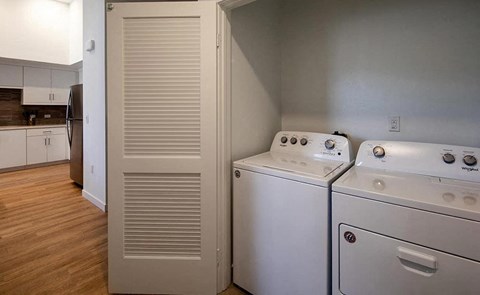 a kitchen with two washer and dryers and a door