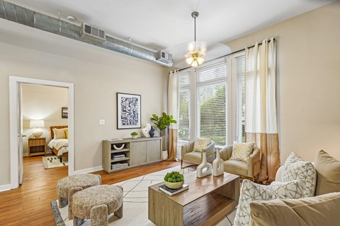 A living room with a brown sofa, a wooden coffee table, and a painting on the wall.