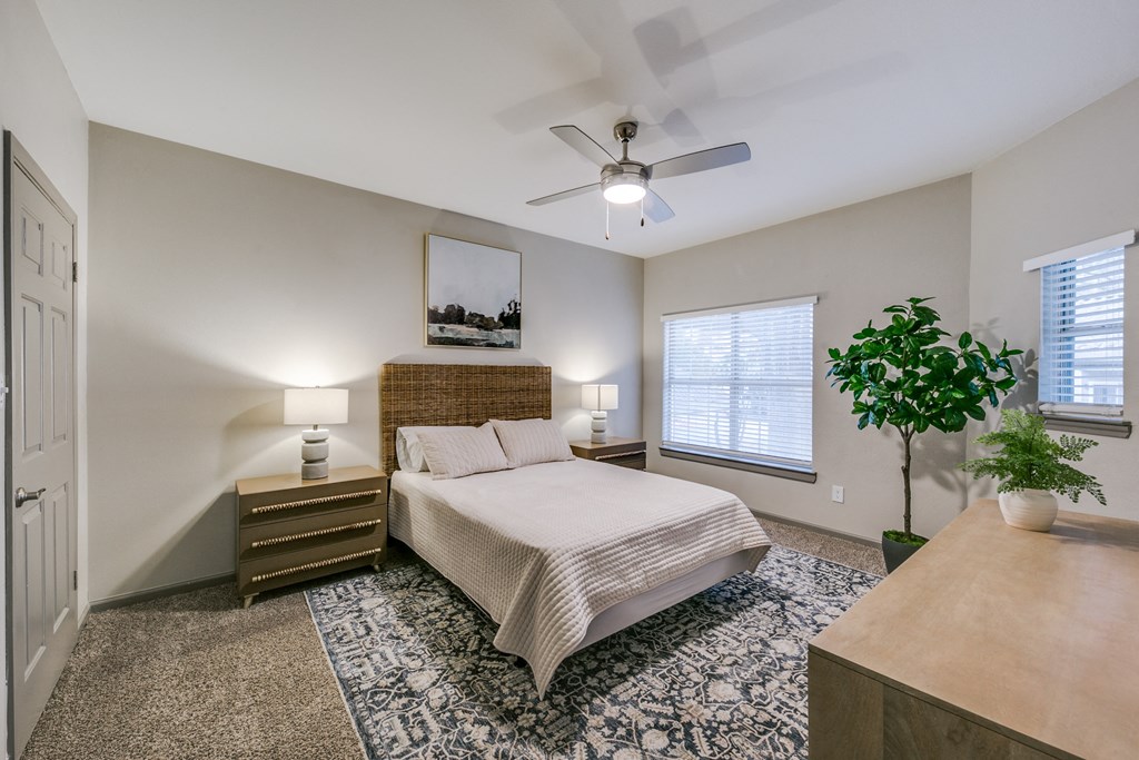 a bedroom with a large bed and a ceiling fan at Canyon Ridge, Austin, 78753