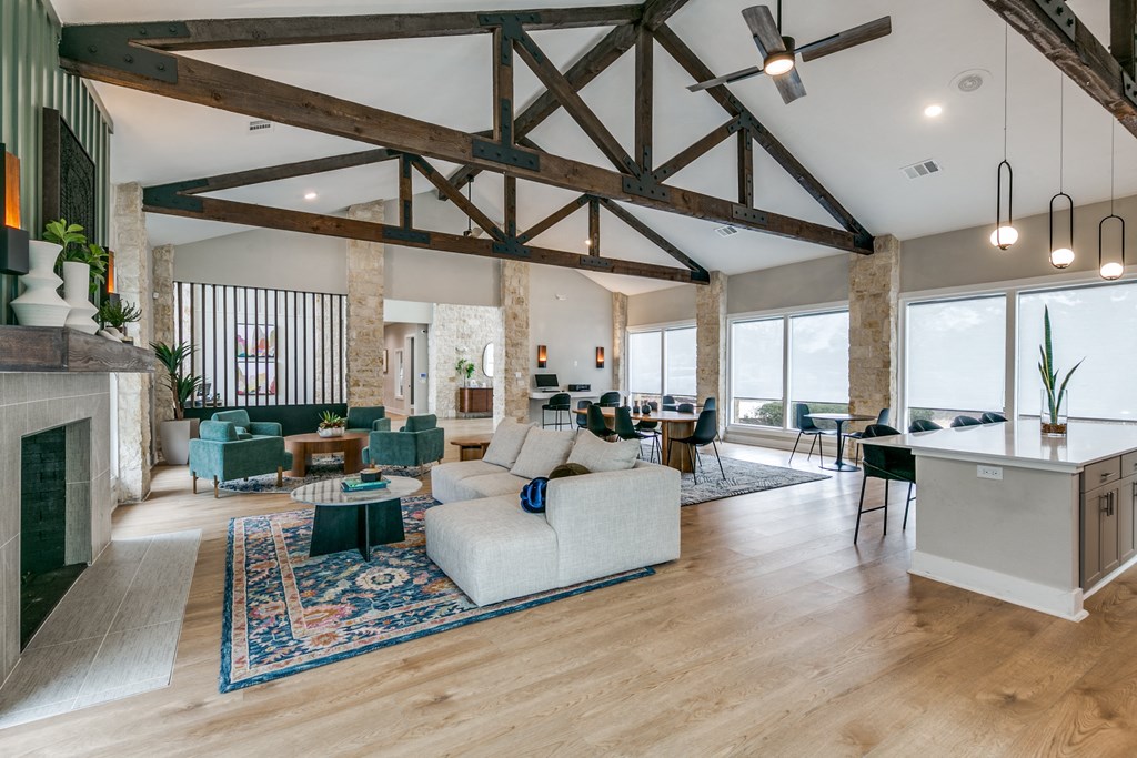the living room and dining room of a house with exposed wood beams and a fireplace at Canyon Ridge, Austin, TX, 78753