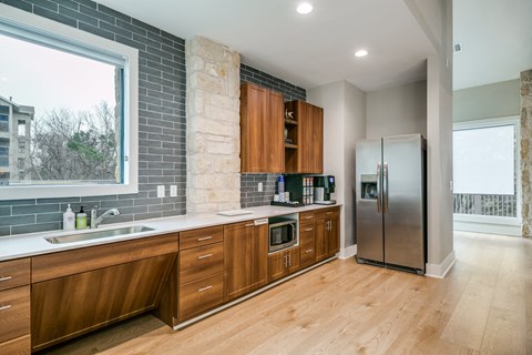 a kitchen with wooden cabinets and a stainless steel refrigerator