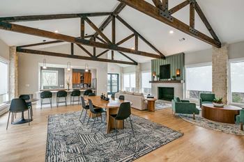A large open living room with a fireplace and a dining table at Canyon Ridge, Austin, Texas