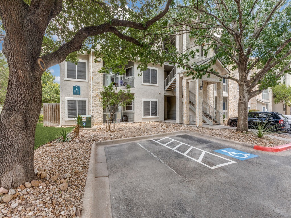 A parking lot with a blue handicap sign painted on the pavement.