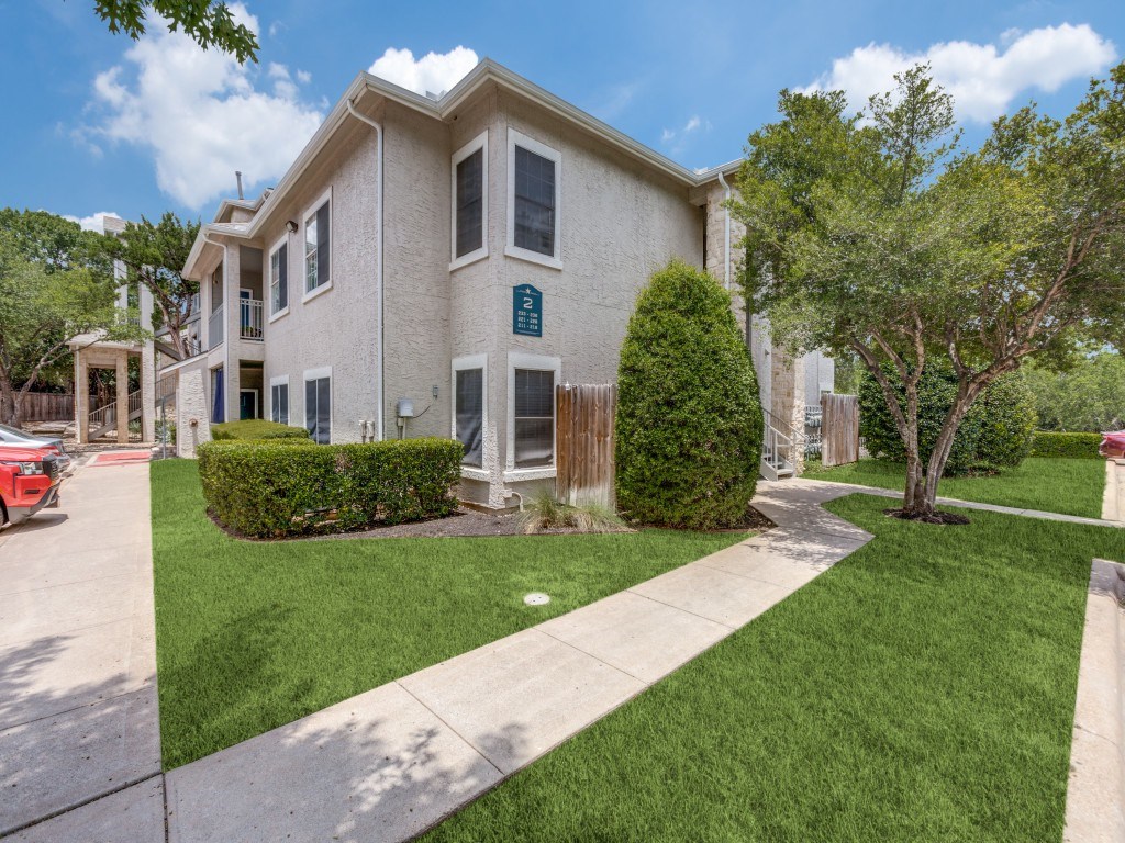A two-story house with a green lawn in front.