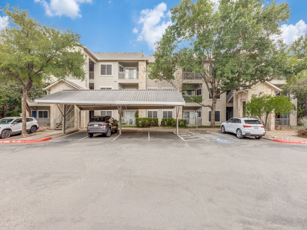 A parking lot with cars and a building in the background.