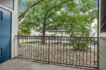 A tree is behind a metal fence at Canyon Ridge, Austin, 78753