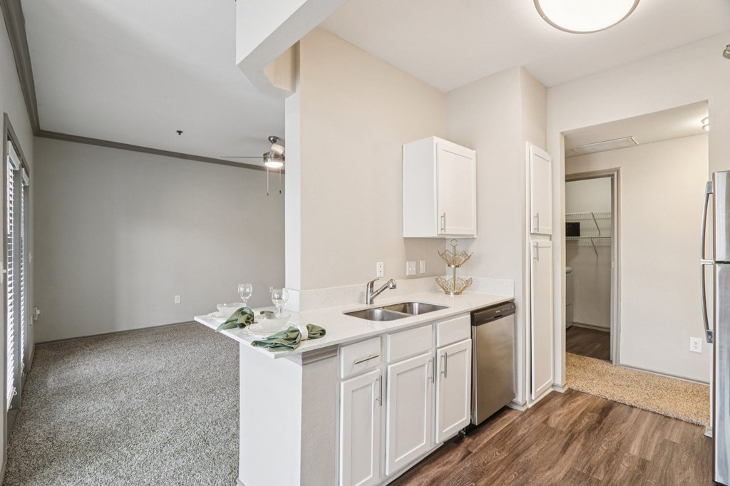 A kitchen with white cabinets and a sink.