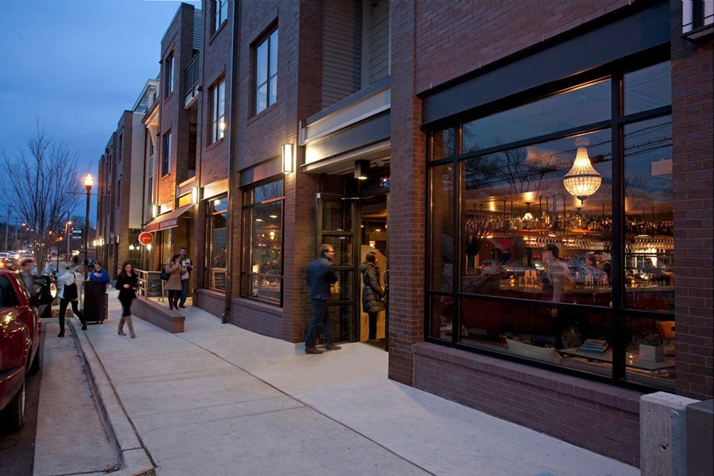 people walking down a sidewalk in front of a building