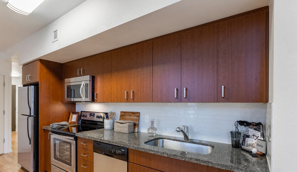 a kitchen with wooden cabinets and a granite counter top