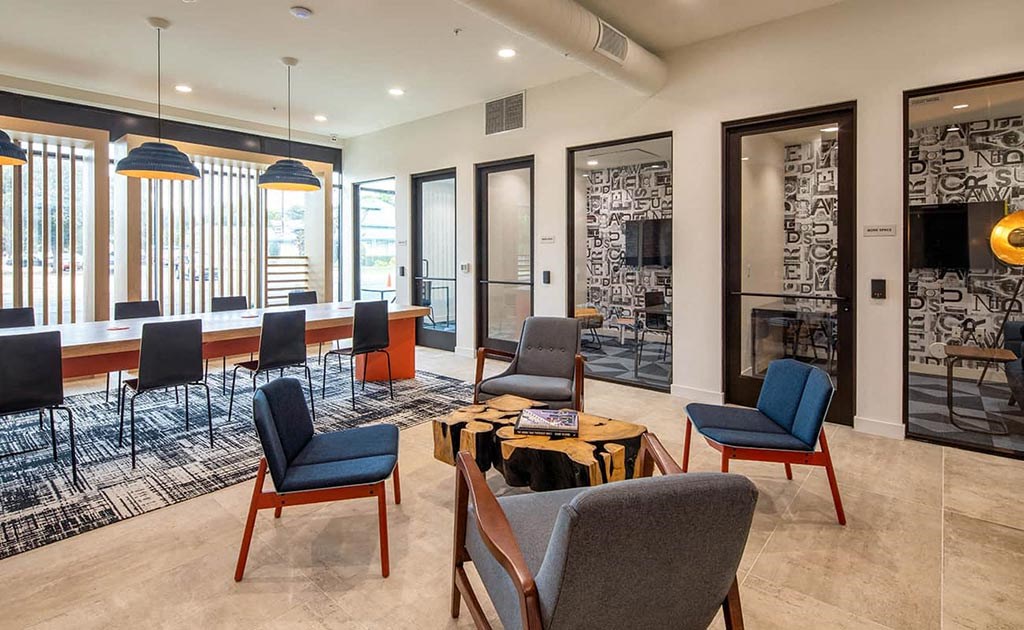 a lounge area with chairs and tables and a fireplace