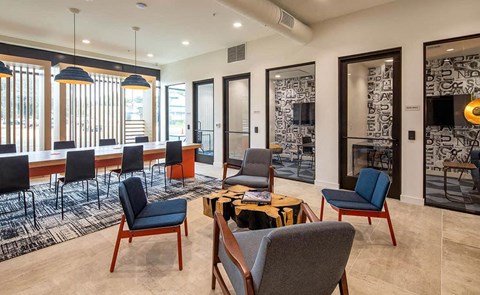 a lounge area with chairs and tables and a fireplace