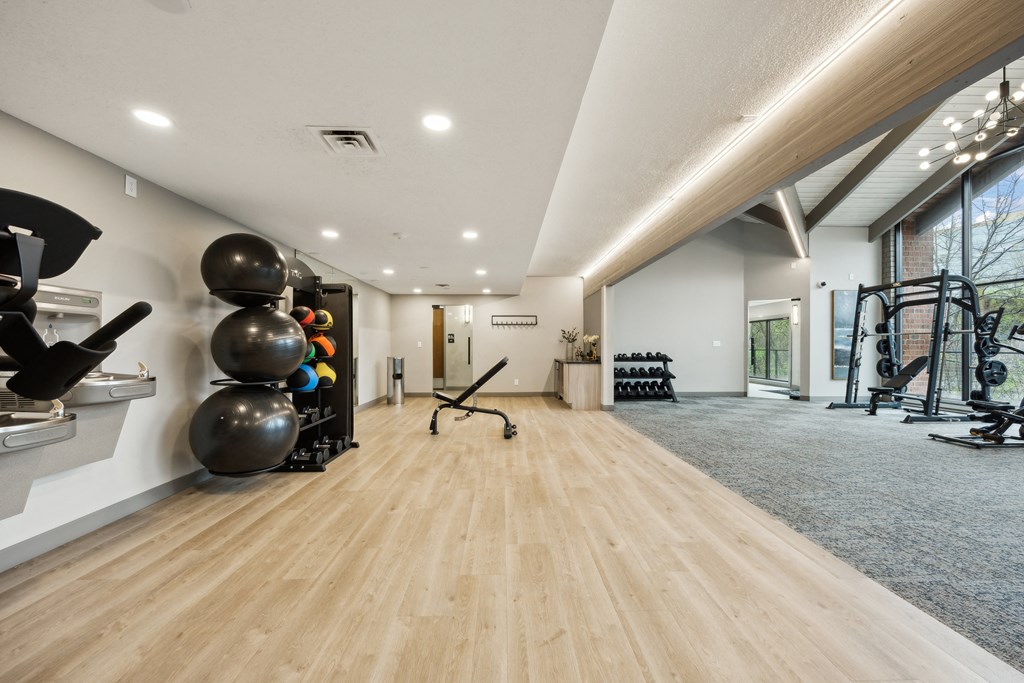 a workout room with weights and mirrors and a large window