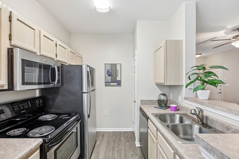 A kitchen with a stove top oven, microwave, and refrigerator.