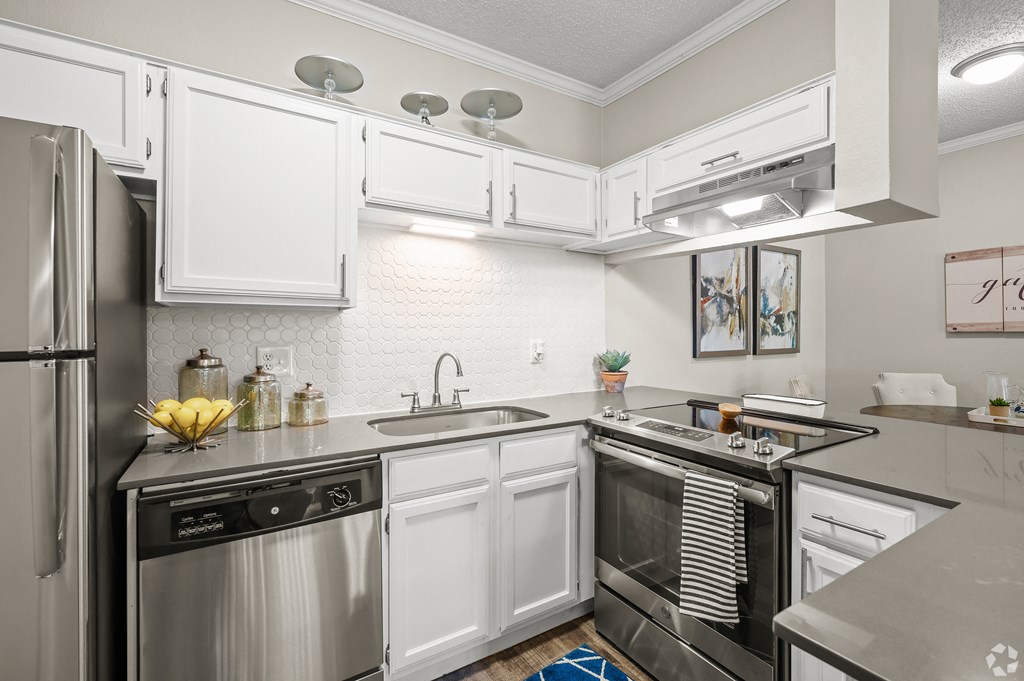 a kitchen with white cabinets and stainless steel appliances