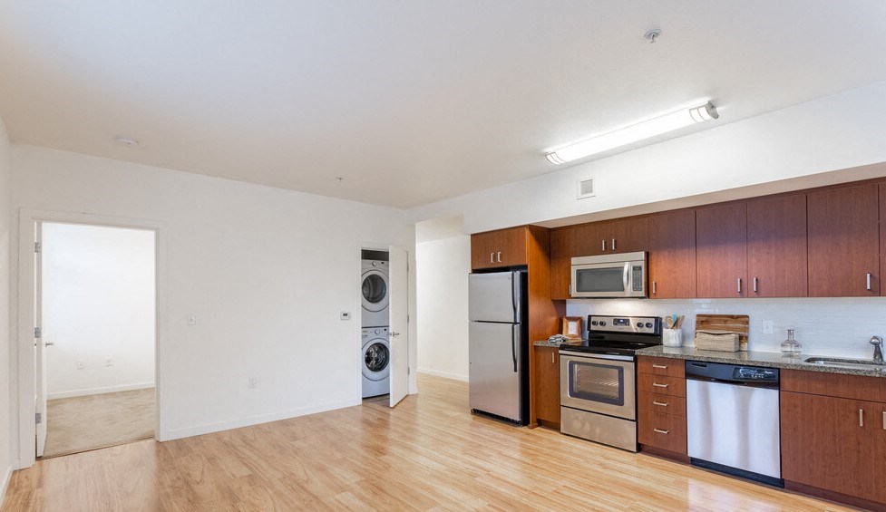 a kitchen and living room with wood floors and white walls