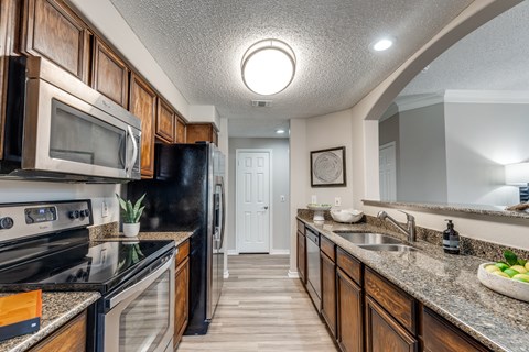 A kitchen with black appliances and wooden cabinets.