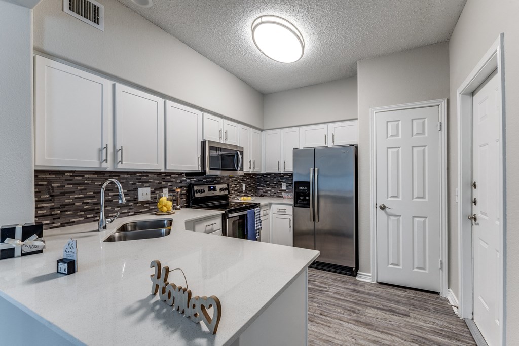 redesigned kitchen with white cabinets and stainless steel appliances at the preserve at great neck apartments