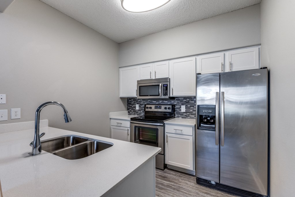an empty kitchen with stainless steel appliances and a sink