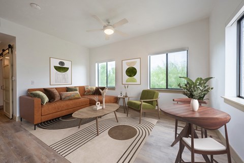 a living room with a brown couch and a table and chairs