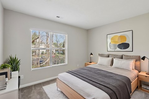 A bedroom with a large bed and a painting on the wall.