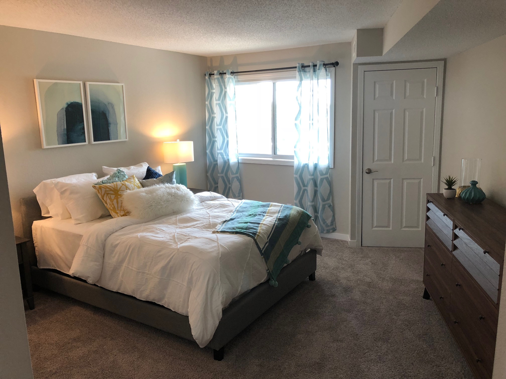 a bedroom with a bed and a dresser and a window