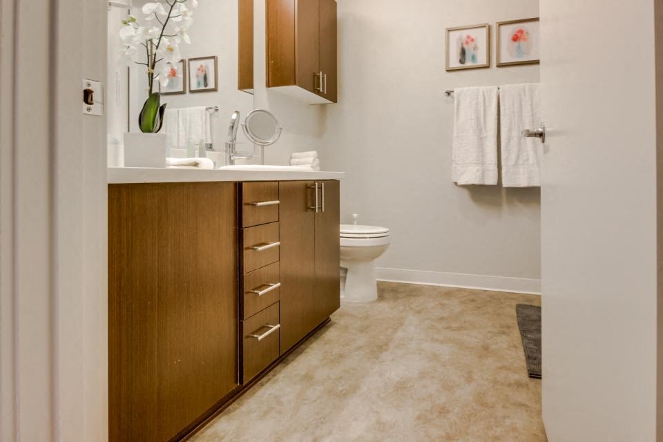 a bathroom with a toilet and a wooden cabinet