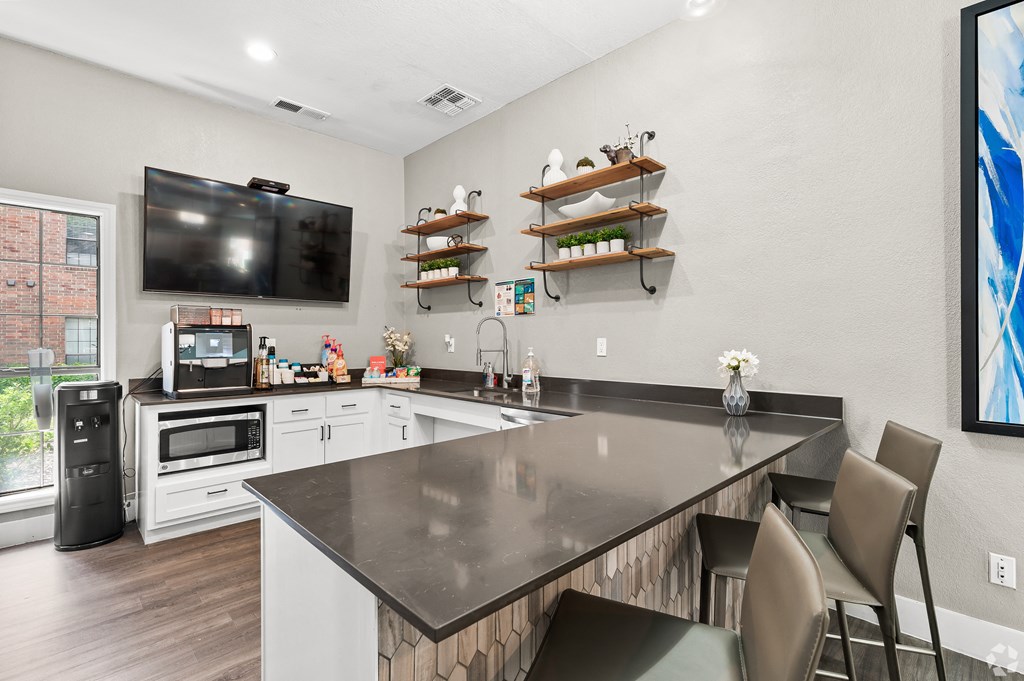 a kitchen with a large center island with a breakfast bar and a flat screen tv on the