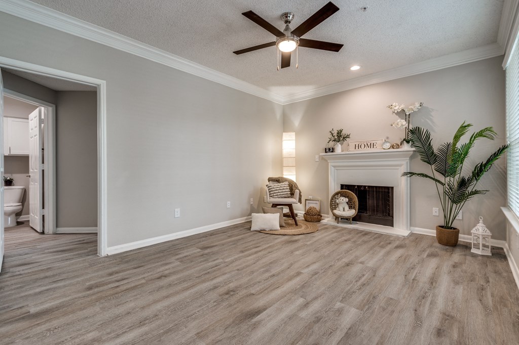a living room with a fireplace and a ceiling fan