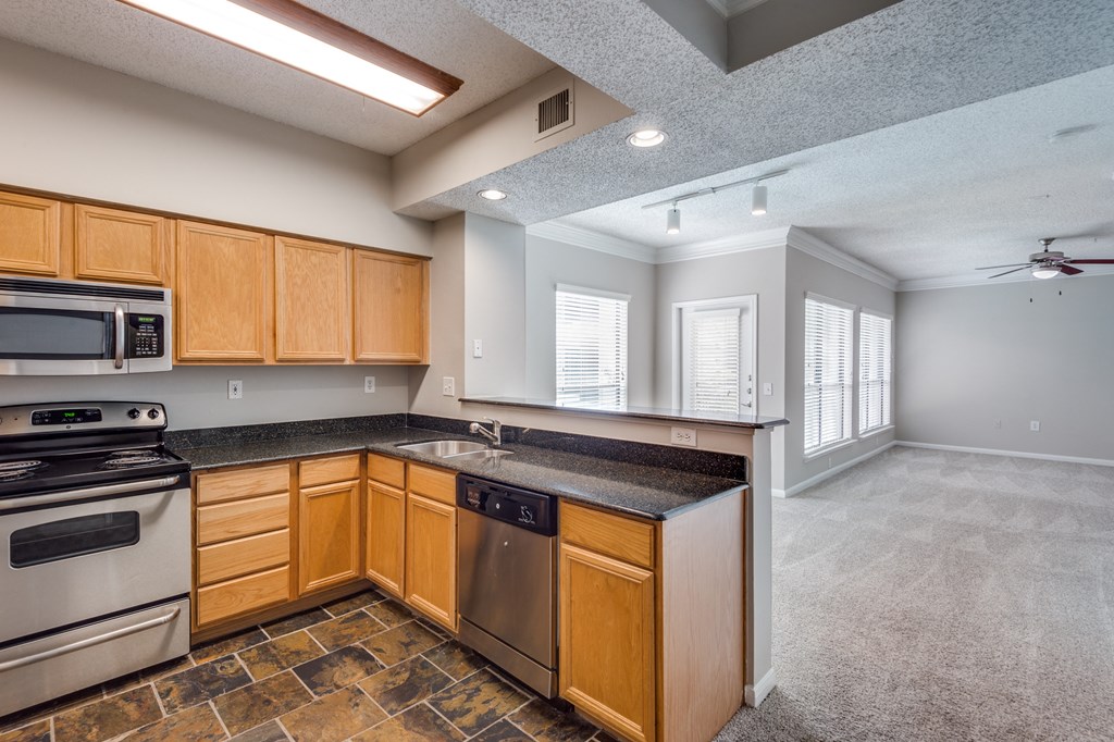 an empty kitchen with wooden cabinets and stainless steel appliances