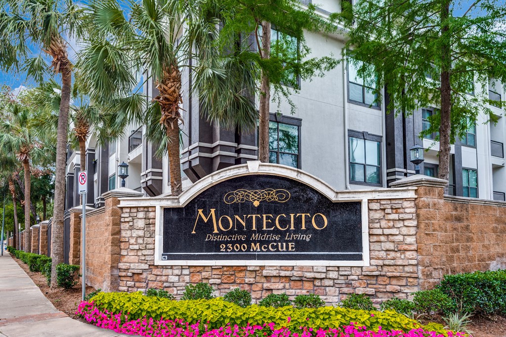 a sign in front of a building with palm trees