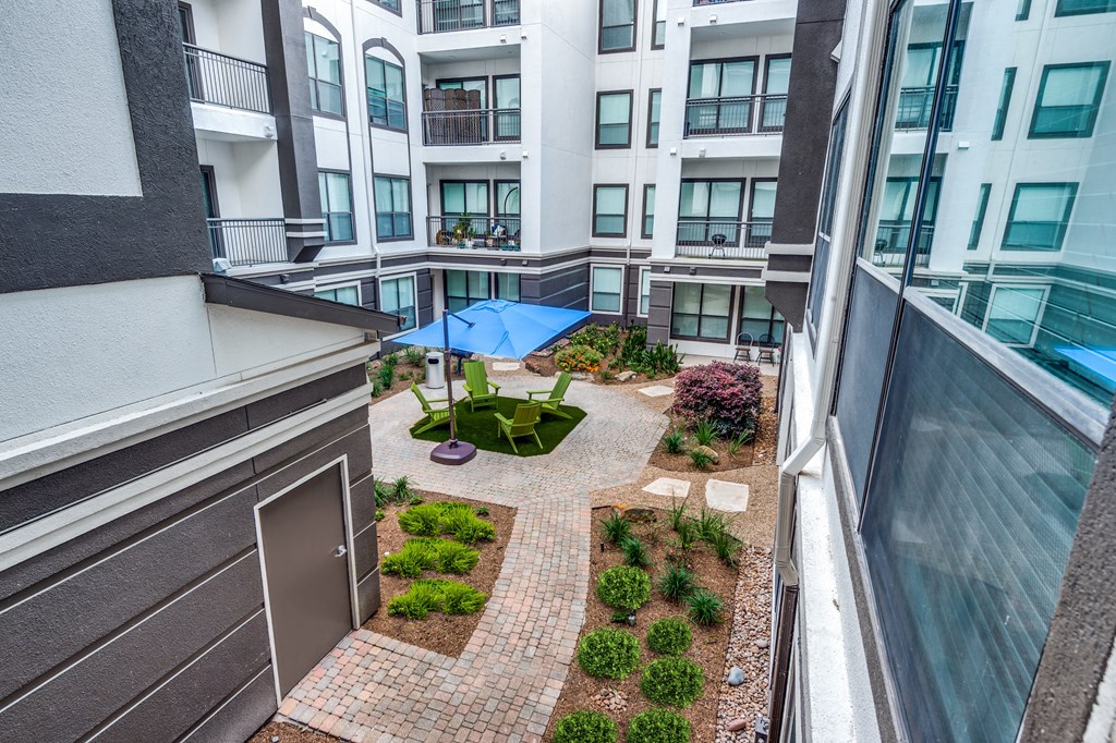 a view of a courtyard from a balcony of an apartment building
