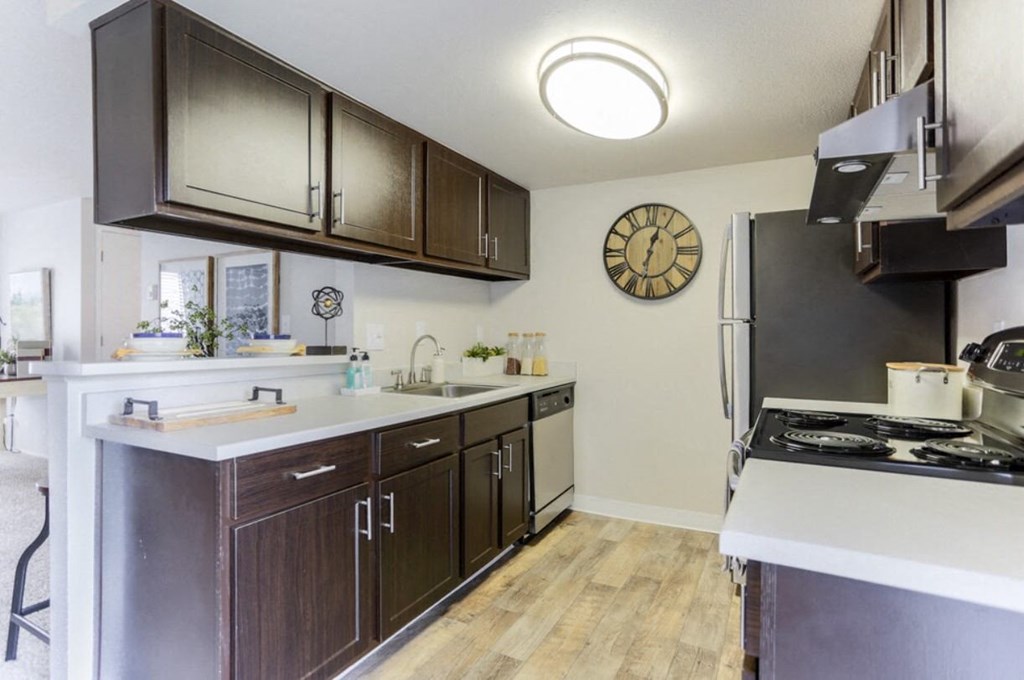a kitchen with stainless steel appliances and a clock on the wall