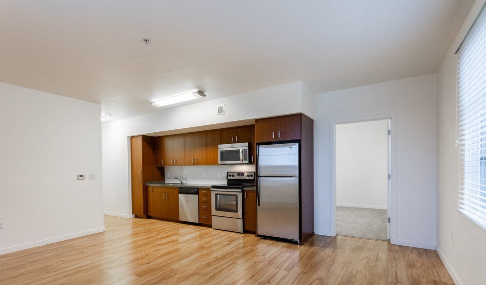 a kitchen with wood floors and stainless steel appliances